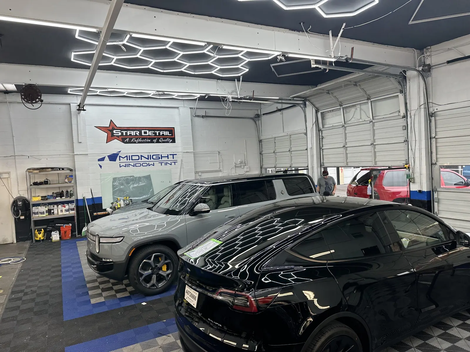 Black SUV under hex lighting in the shop bay